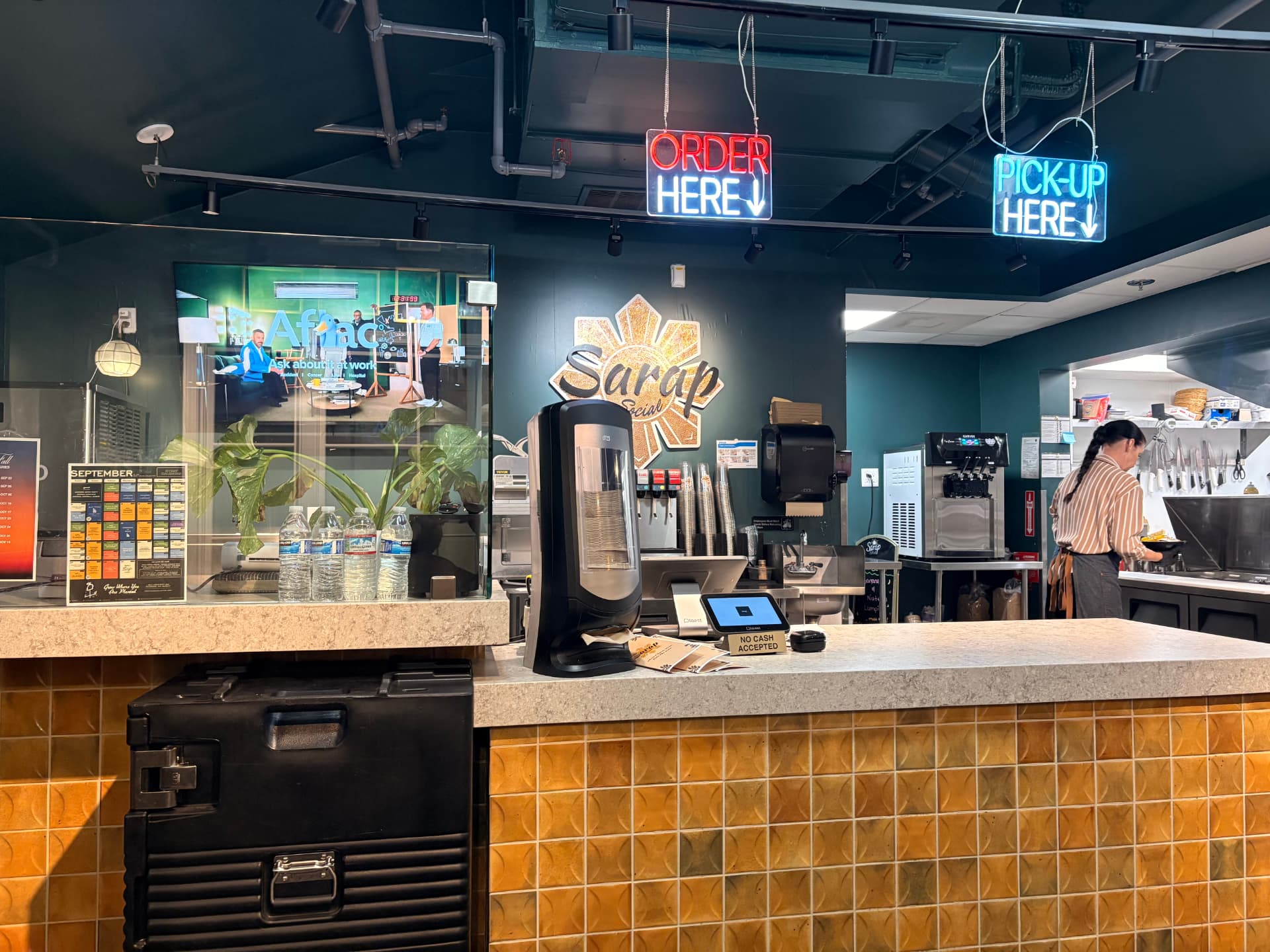 Sarap Social counter with order and pickup neon signs